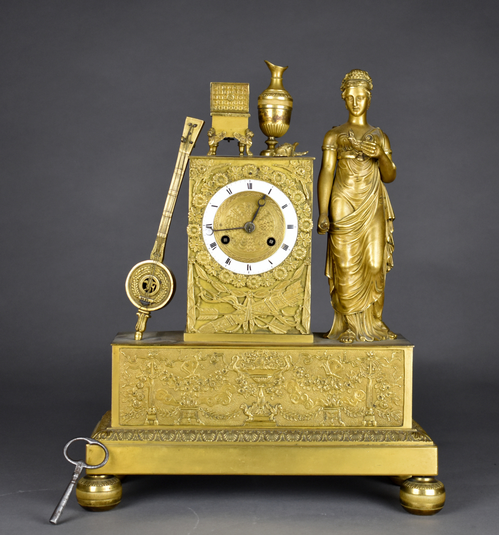 Pendule en bronze ciselé doré orné d'une vestale et d'une mandoline